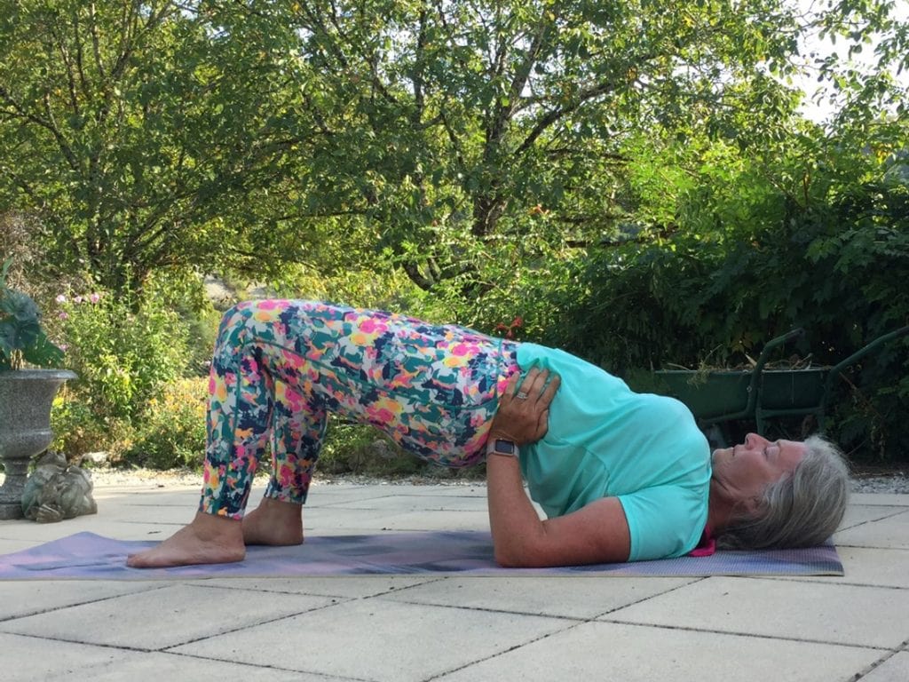 Woman in bridge yoga posture to gain reduces headaches and migraines